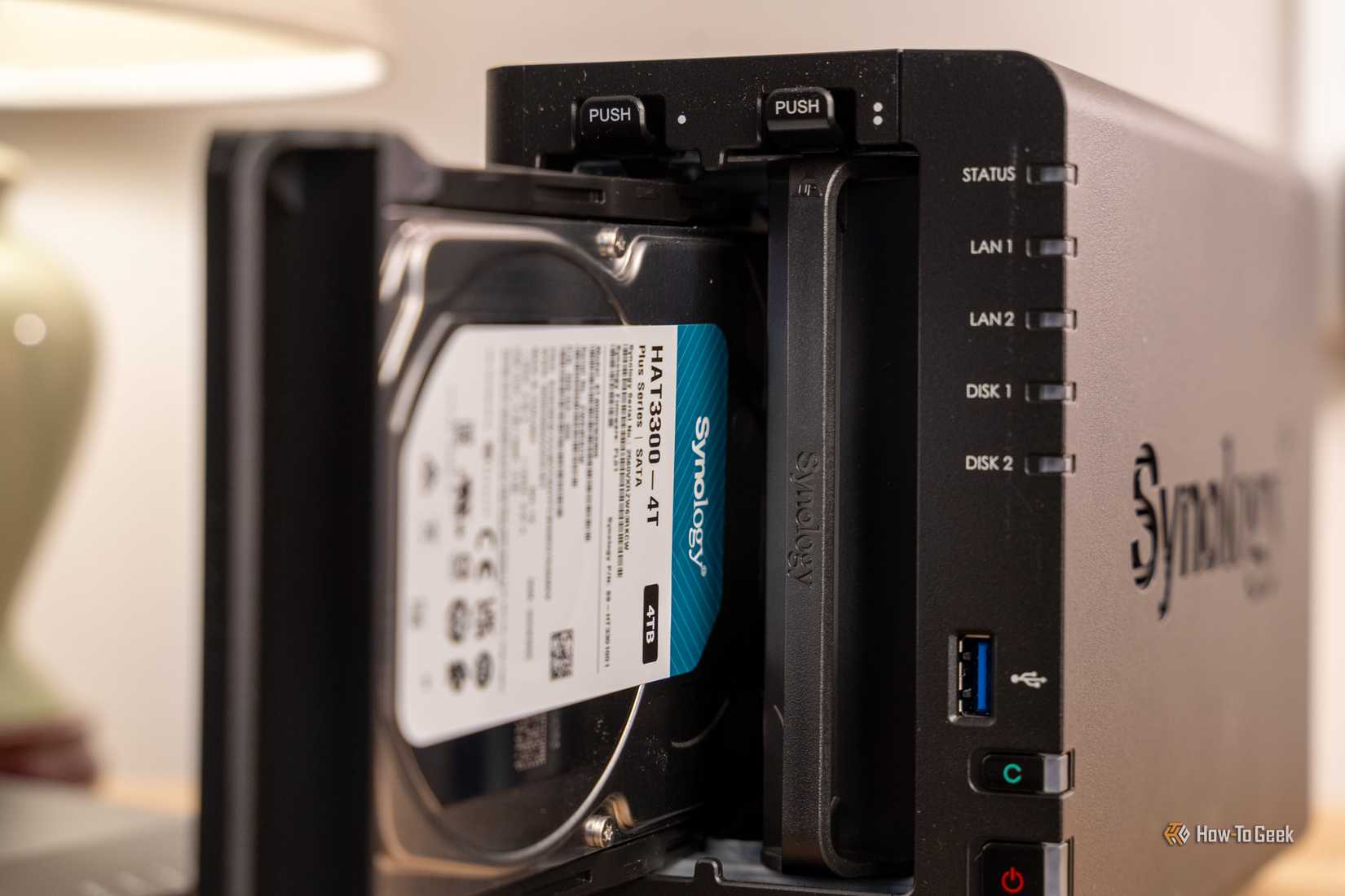 Synology HAT3300-4T hard drive partially inserted into the DS225 Plus NAS bay.