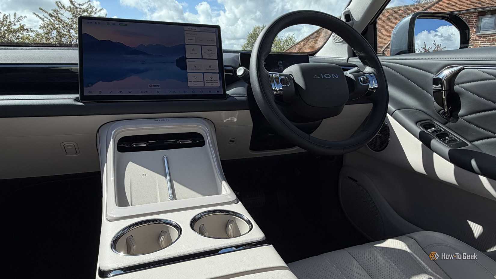 Closeup shot of the infotainment screen and steering wheel on the dashboard of an AION V.