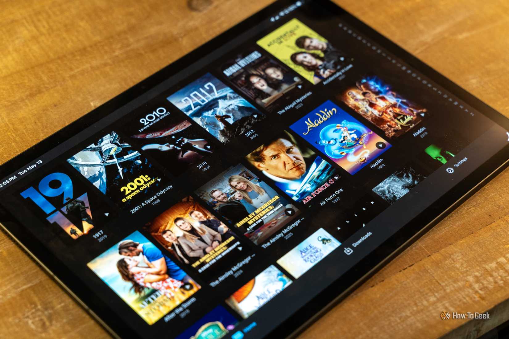 Angled iPad view of Jellyfin movie poster grid on a wood table.