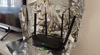 A Wi-Fi 7 router surrounded by aluminum foil.