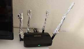 A Wi-Fi router with the antennas extended using aluminum foil.