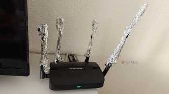 A Wi-Fi router with the antennas extended using aluminum foil.
