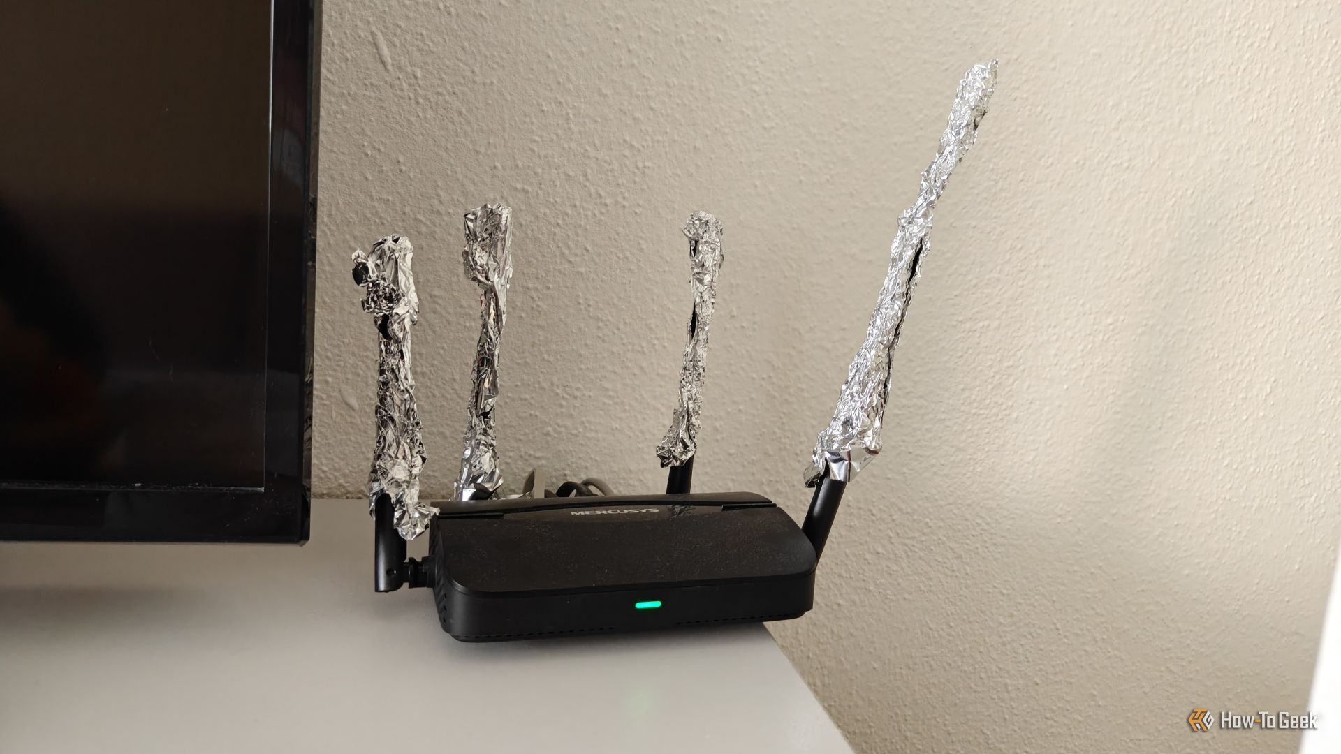 A Mercusys Wi-Fi 7 router with aluminum foil on the antennas.