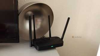 A Mercusys Wi-Fi 7 router with a metal bowl behind it.