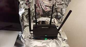 A Wi-Fi router sitting inside a partial Faraday Cage made of aluminum foil.