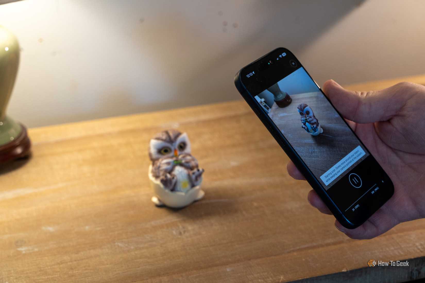 iPhone scanning a painted owl figurine for comparison with a dedicated 3D scanner.