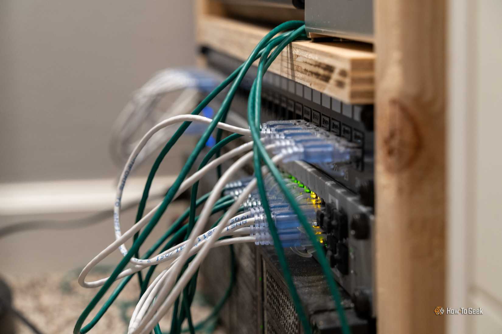 Side-angle close-up of UniFi US-48-500W managed PoE network switch cables and link lights.