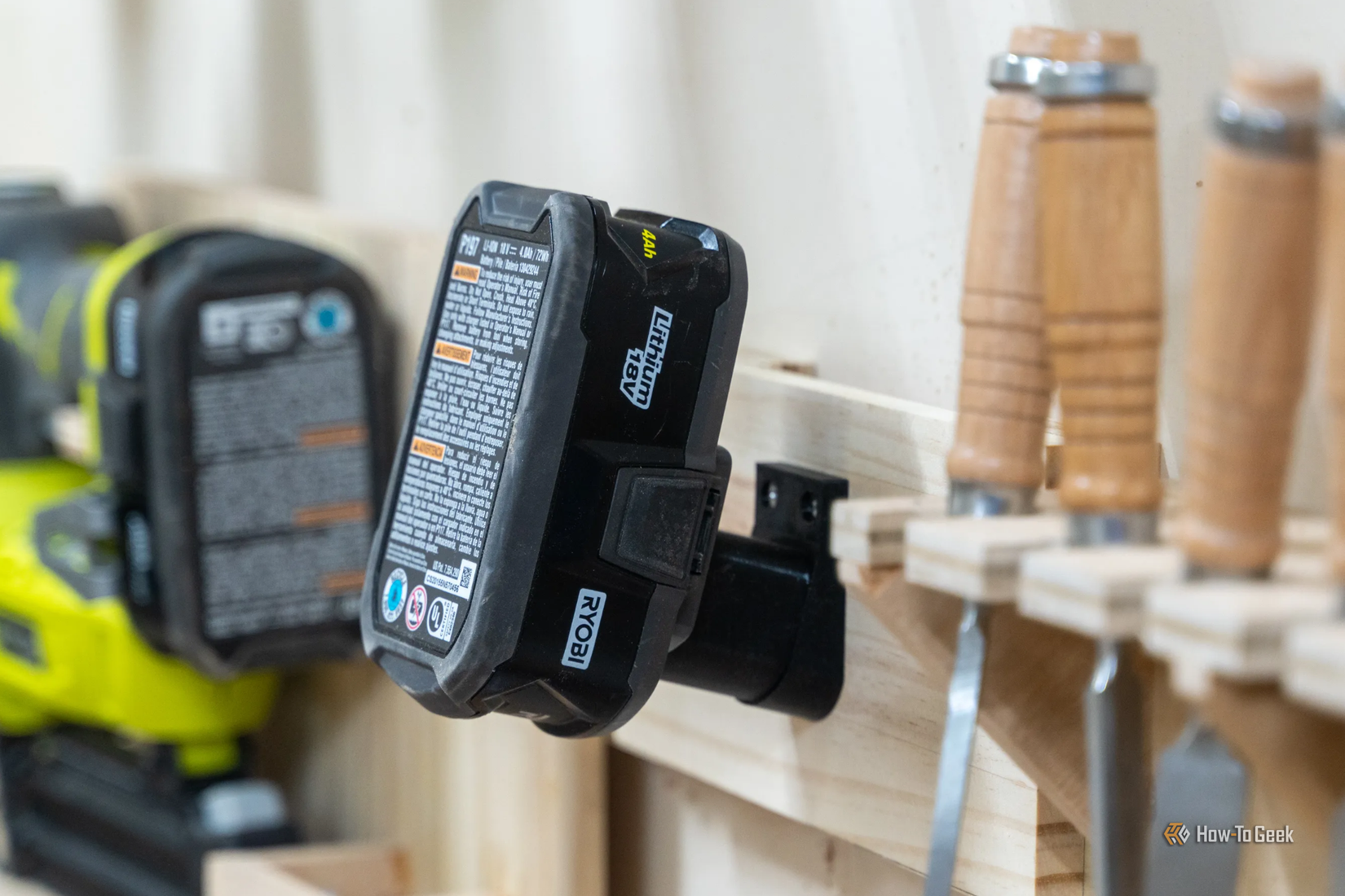 A 3D printed RYOBI battery holder with a battery mounted on a wall.