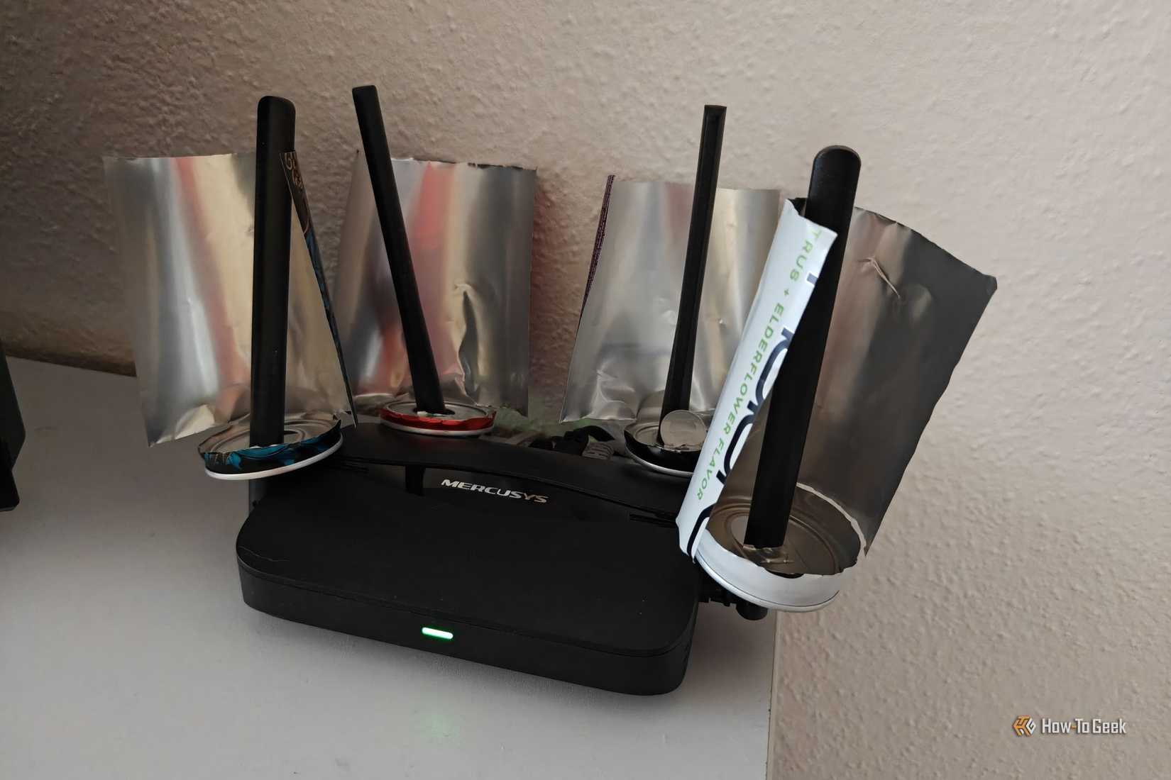 A Wi-Fi router with a bunch of soda cans on it.