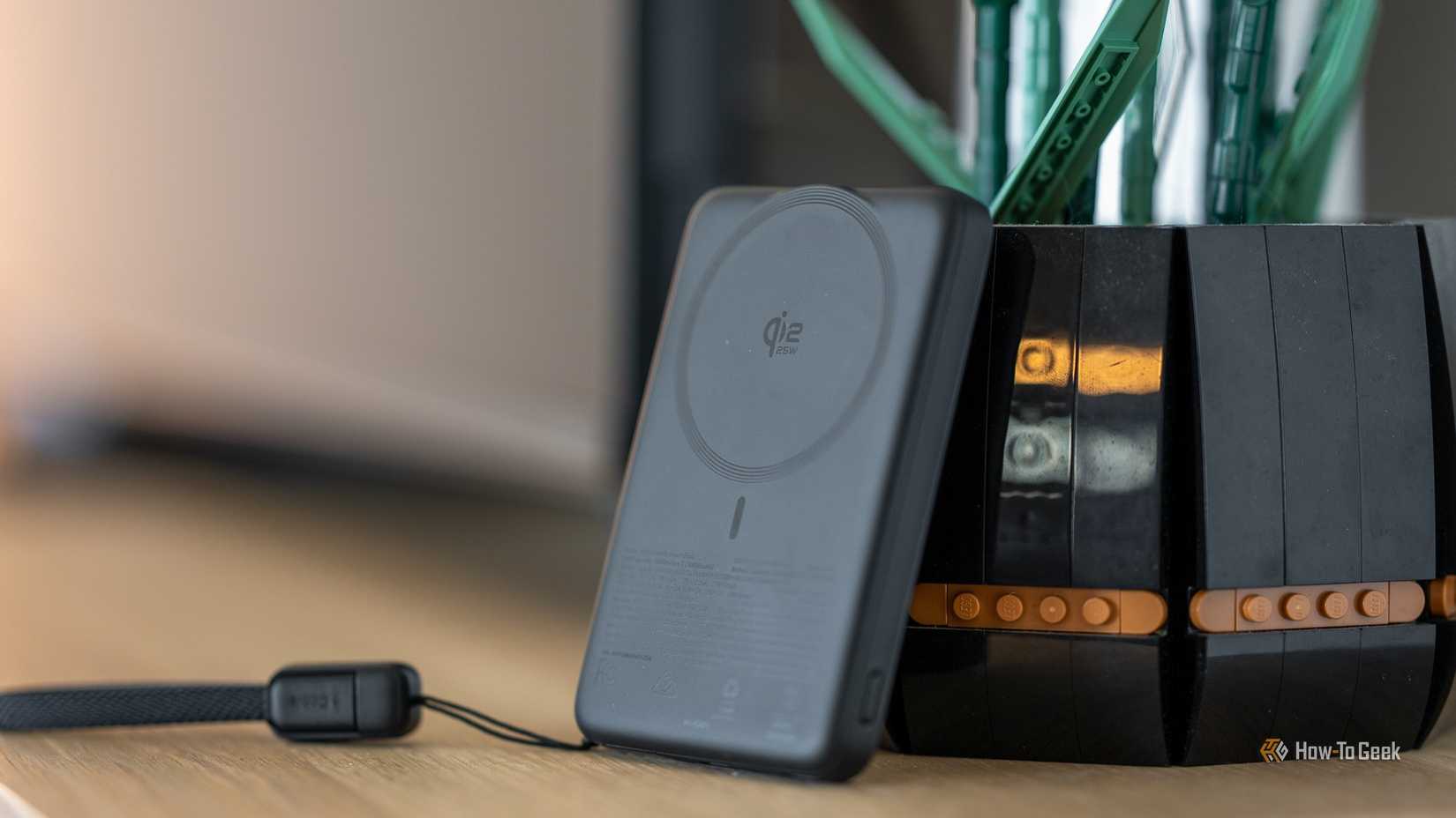 INIU SnapGo Air Power Bank Qi2 wireless charging back leaning against LEGO plant pot warm edit.