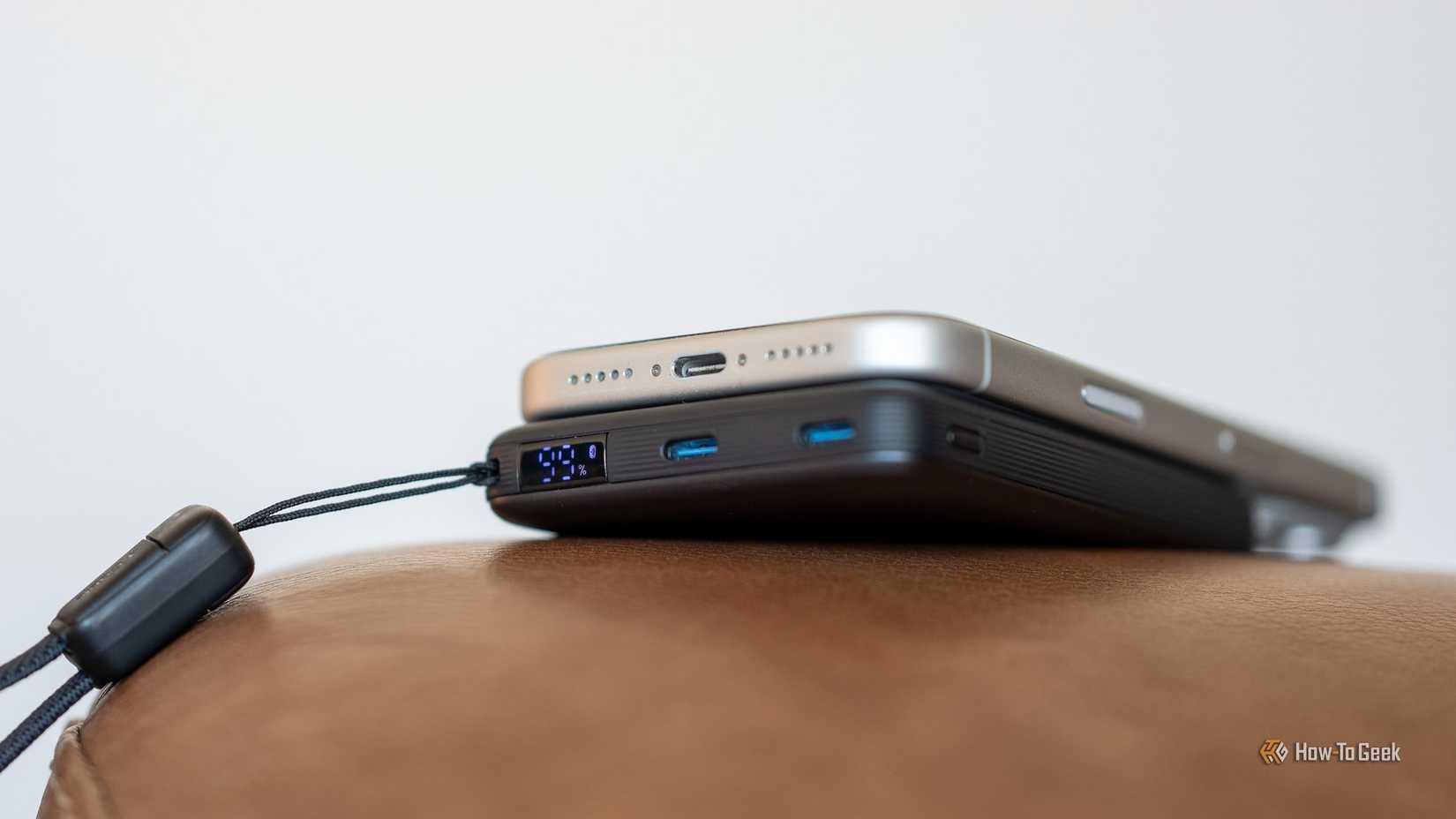 INIU SnapGo Air Power Bank side view magnetically attached to iPhone showing LED battery display and USB-C ports.