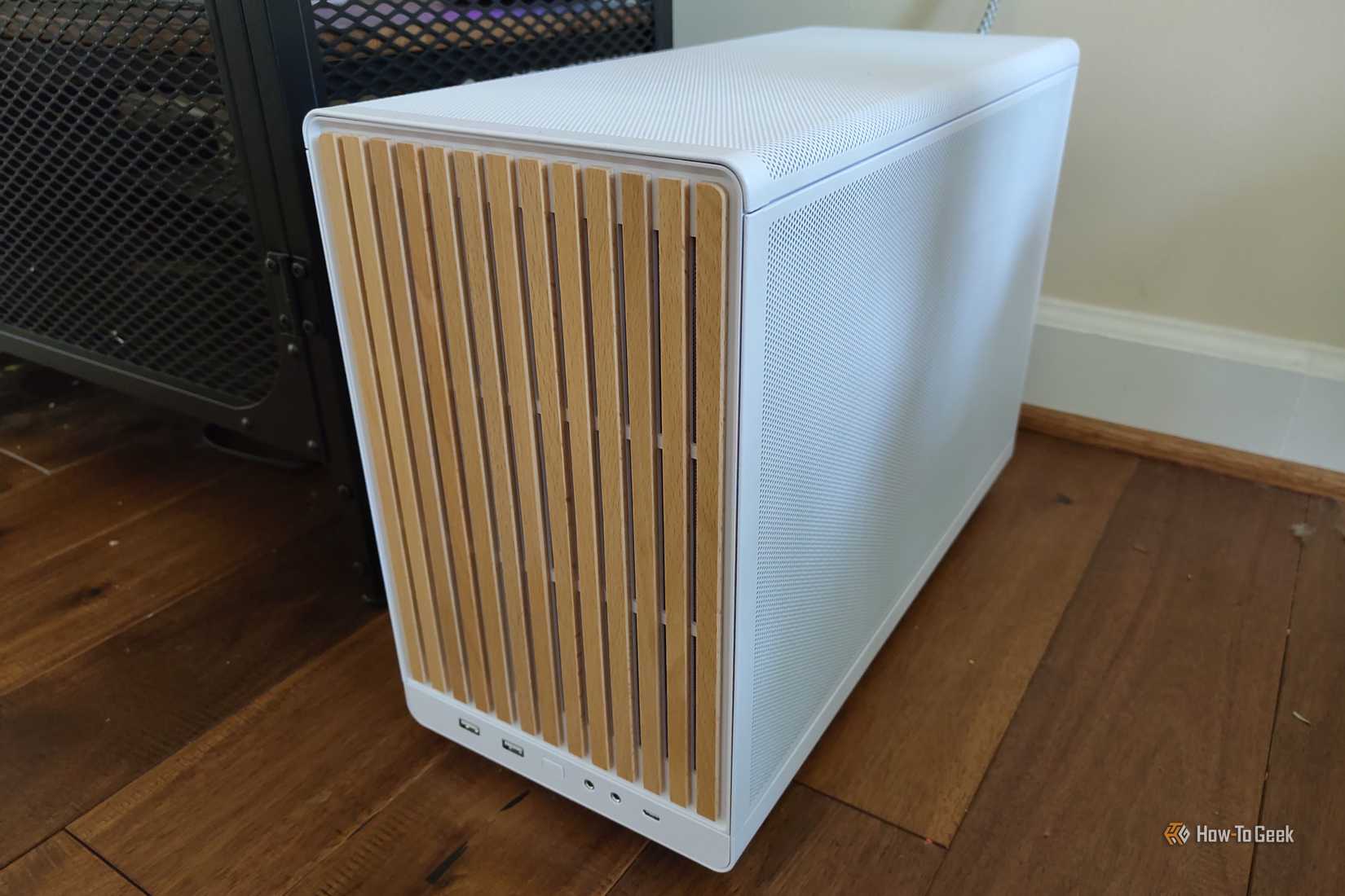 PC tower on the floor next to a TV stand.
