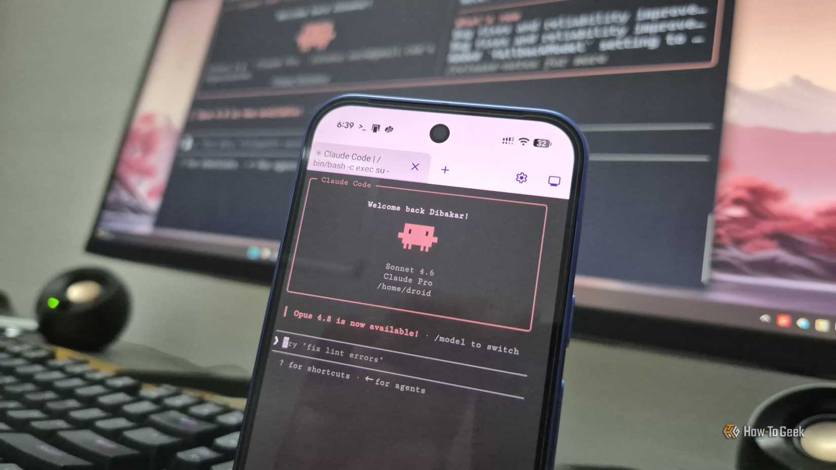 Pixel 10 phone showing Claude Code welcome screen running on a desk next to a keyboard.