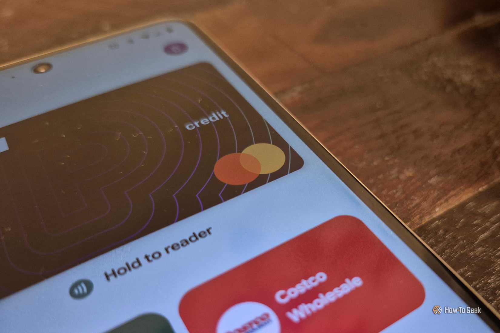 Les cartes s'ouvrent dans l'application Google Wallet sur un téléphone posé sur une surface en bois. 