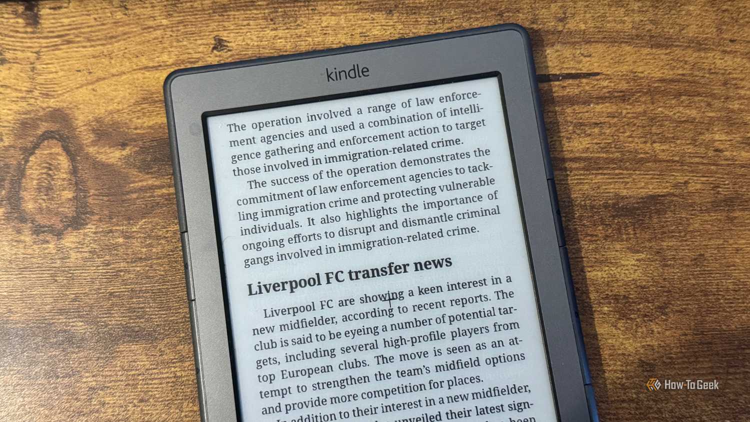 A close up of a Kindle 4 showing the end of the UK immigration crime crackdown article and the start of the Liverpool FC transfer news section.