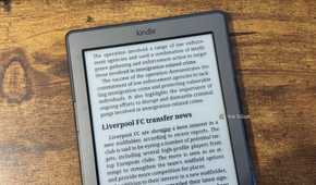 A close up of a Kindle 4 showing the end of the UK immigration crime crackdown article and the start of the Liverpool FC transfer news section.