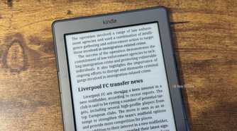 A close up of a Kindle 4 showing the end of the UK immigration crime crackdown article and the start of the Liverpool FC transfer news section.