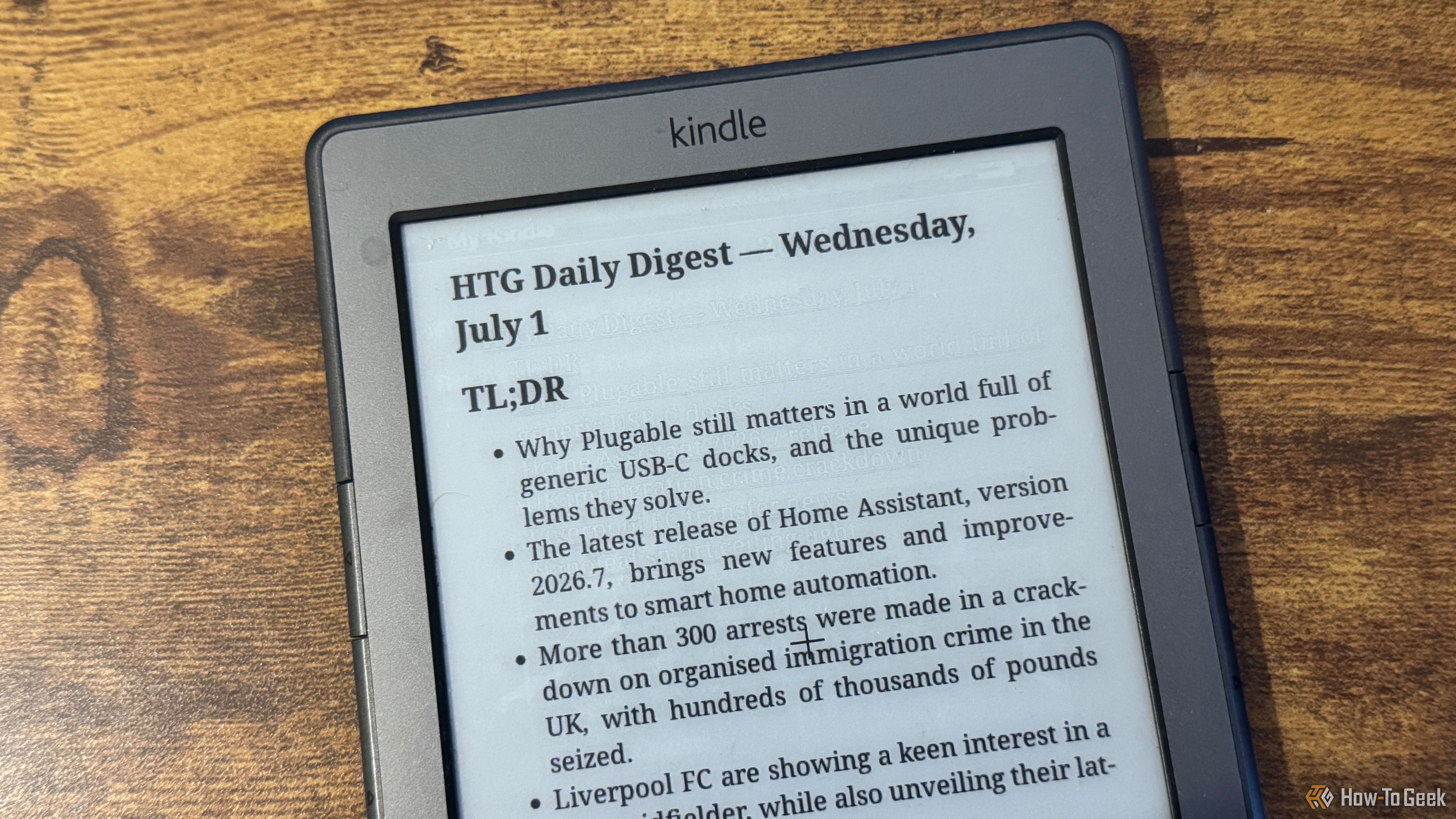 A close up of a Kindle 4 showing the HTG Daily Digest TLDR bullet list covering Plugable Home Assistant immigration crime and Liverpool FC.
