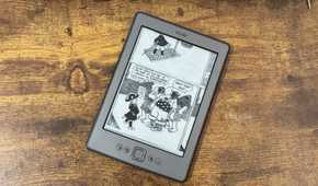 A Kindle 4 running KOReader showing a CBZ comic panel with a boy demanding the surrender of a pirate ship while pirates laugh.