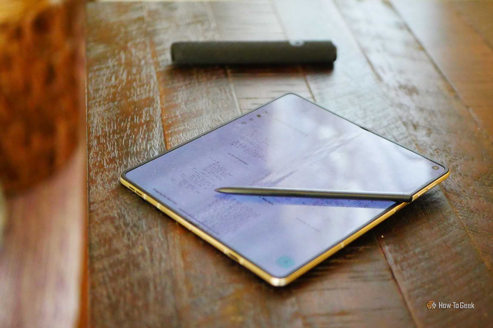 A Moto Pen Ultra on top of an unfolded Motorola Razr Fold displaying a notes app. 