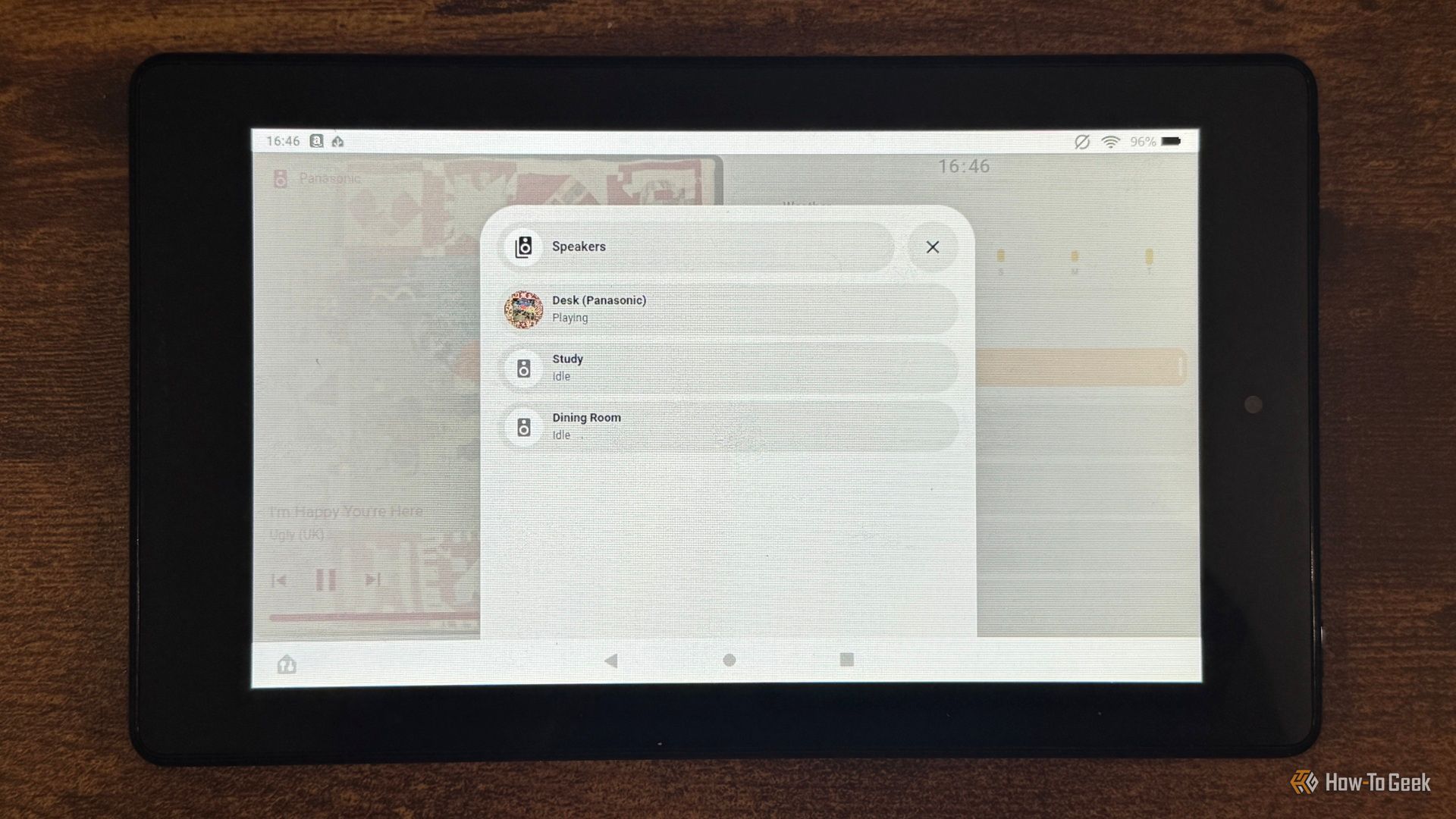 A tablet showing the Home Assistant Speakers list with Desk Panasonic Study and Dining Room photographed closer.
