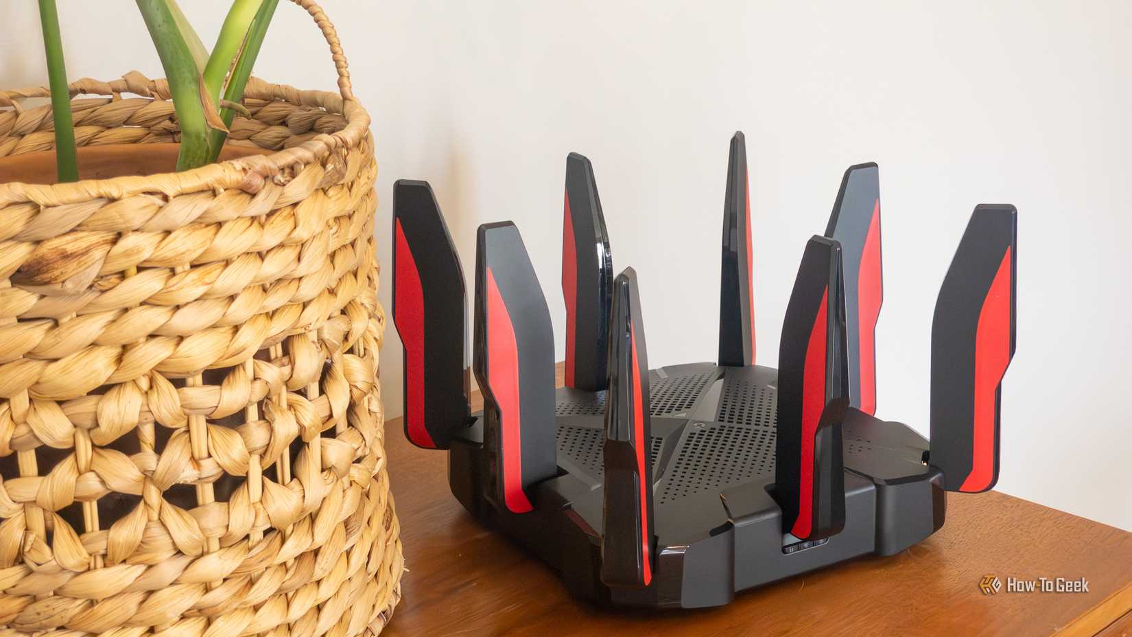TP-Link's Archer GX90 Wi-Fi 6 router sitting on a table next to a plant.