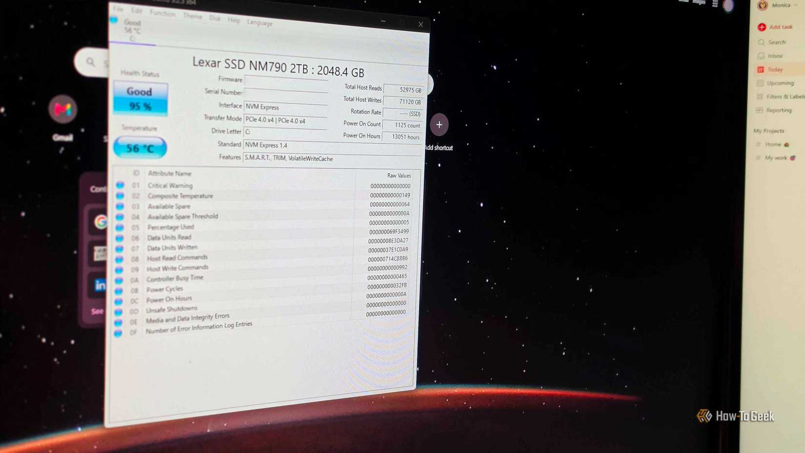 CrystalDiskInfo on a computer monitor, with another monitor next to it.