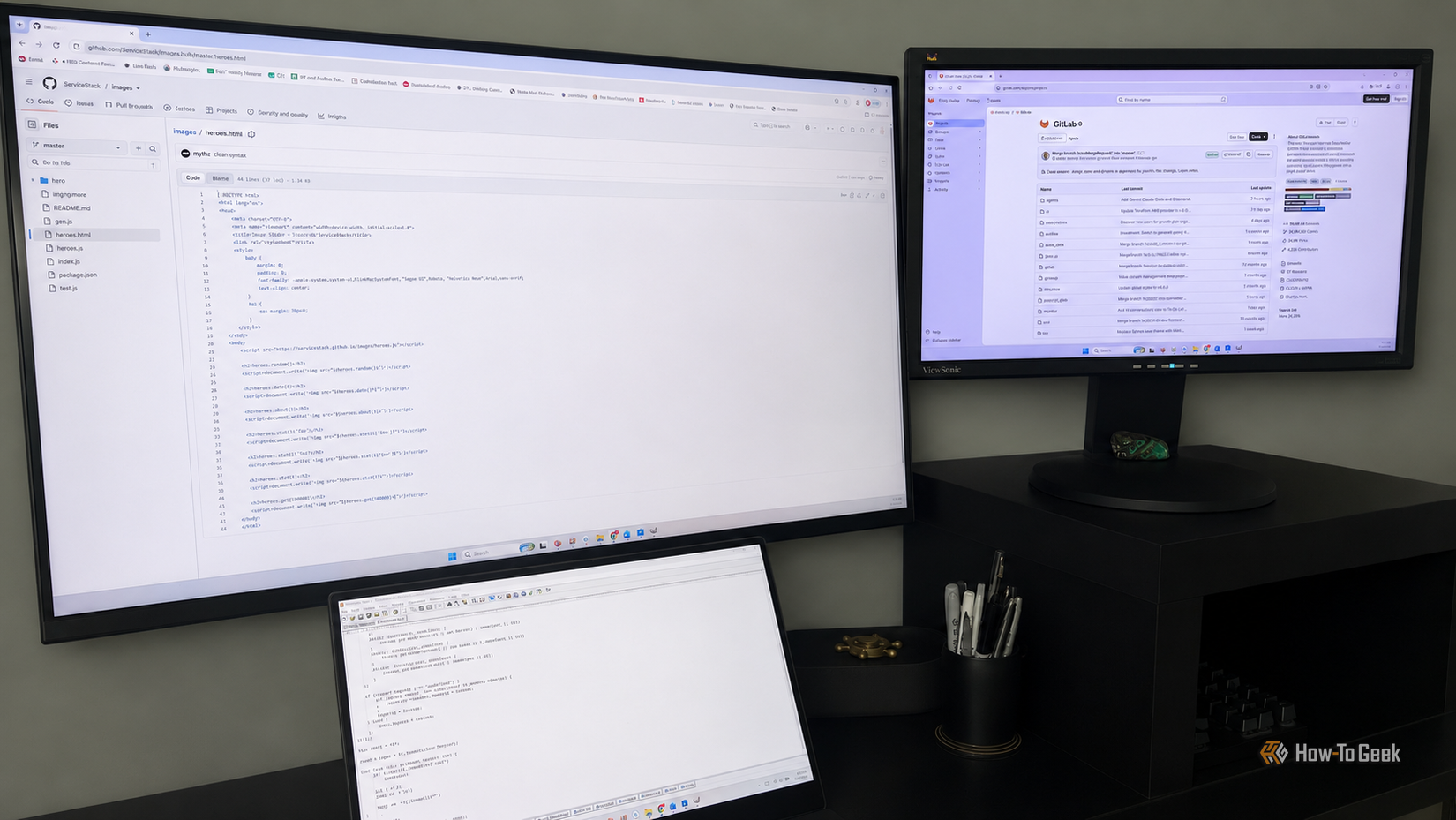 An image of 3 monitors, one with a GitHub repo, the other a GitLab repo, and the third monitor has an editor open with JavaScript open.