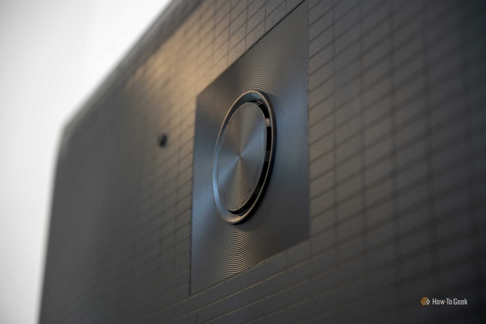 Close-up of the Hisense U6SF Pro back panel showing a circular speaker driver with concentric ridges against a textured grid surface.