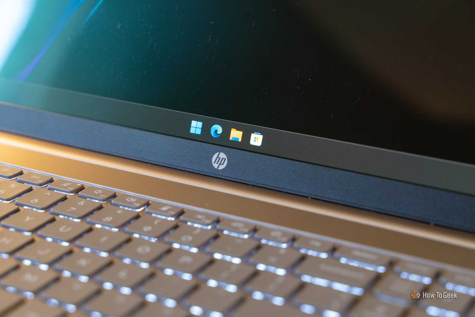 HP OmniBook 3 display bezel HP logo and backlit keyboard detail.
