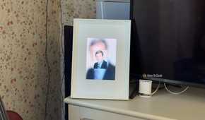 Raspberry Pi photo frame made from an iPad 2 panel displaying a blurry glitched portrait of a man in a suit.