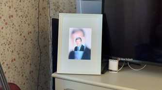 Raspberry Pi photo frame made from an iPad 2 panel displaying a blurry glitched portrait of a man in a suit.