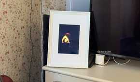 Raspberry Pi photo frame made from an iPad 2 panel displaying a glowing jack o lantern in a dark room.