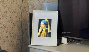 Raspberry Pi photo frame made from an iPad 2 panel displaying a parody of Girl with a Pearl Earring with a finger in the nose.