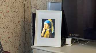 Raspberry Pi photo frame made from an iPad 2 panel displaying a parody of Girl with a Pearl Earring with a finger in the nose.