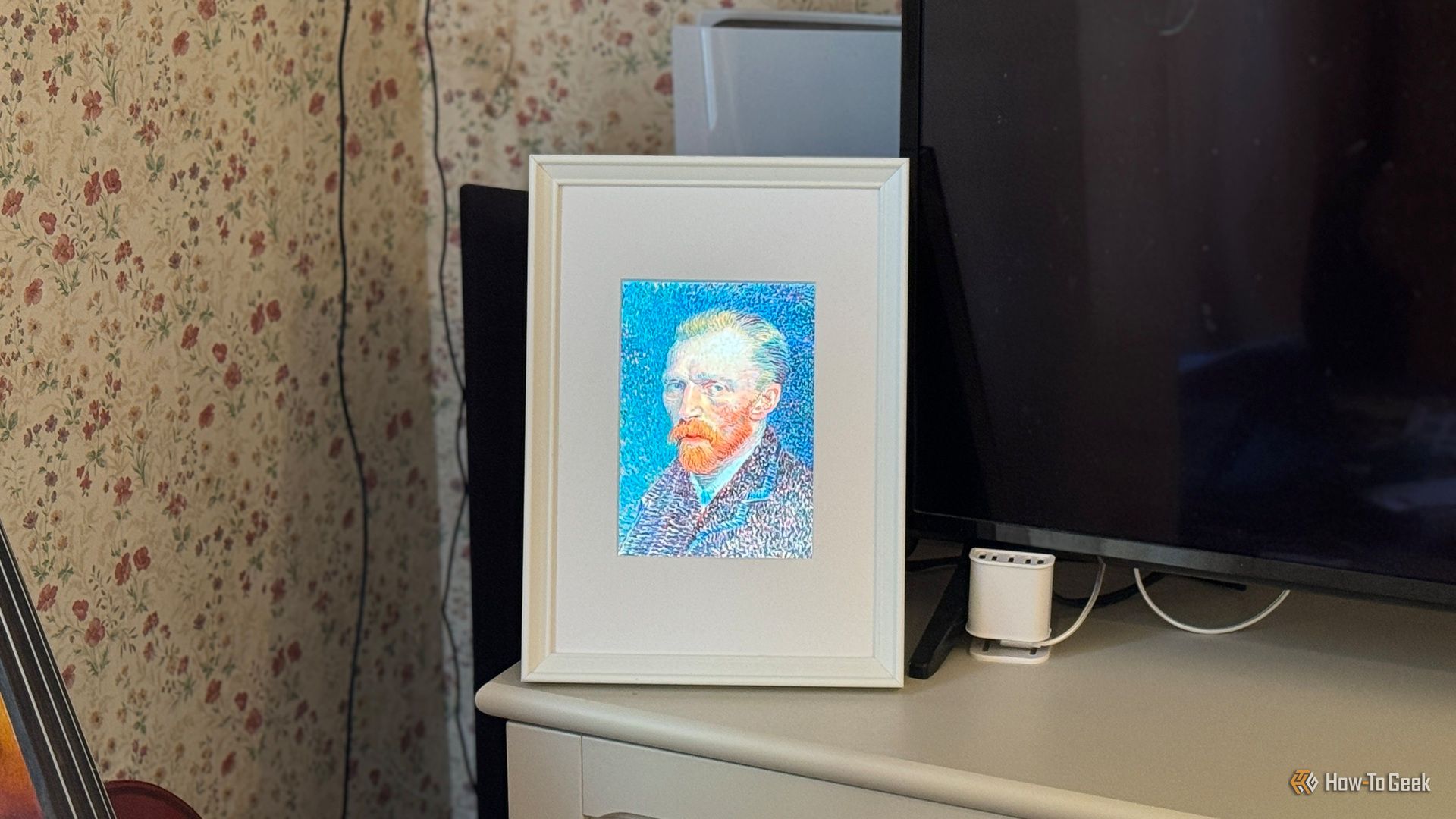 Raspberry Pi photo frame made from an iPad 2 panel displaying a Van Gogh self portrait beside a TV.
