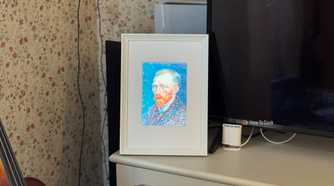 Raspberry Pi photo frame made from an iPad 2 panel displaying a Van Gogh self portrait beside a TV.