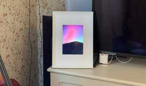 Raspberry Pi photo frame made from an iPad 2 panel displaying the Northern Lights over a mountain silhouette.