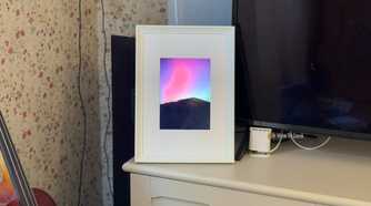 Raspberry Pi photo frame made from an iPad 2 panel displaying the Northern Lights over a mountain silhouette.