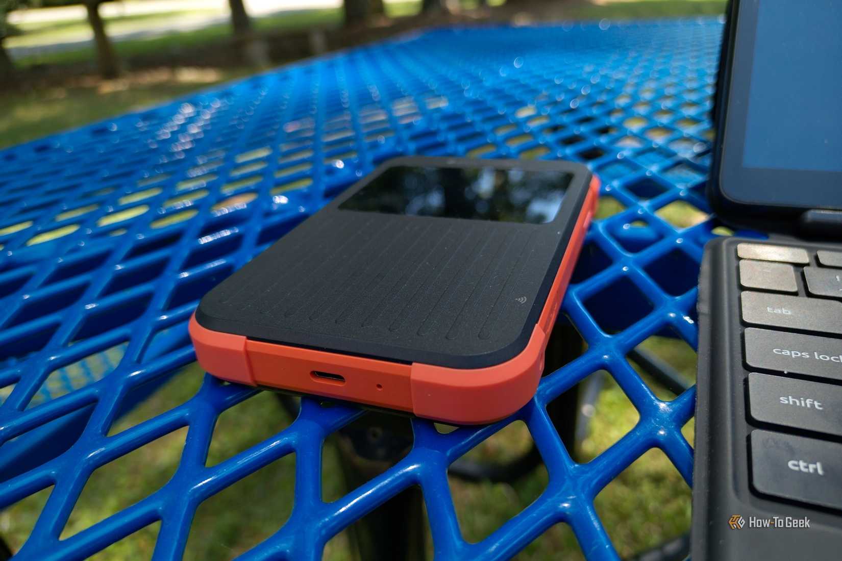 Solis Pro 5G hotspot next to a tablet PC keyboard on a blue outdoor table