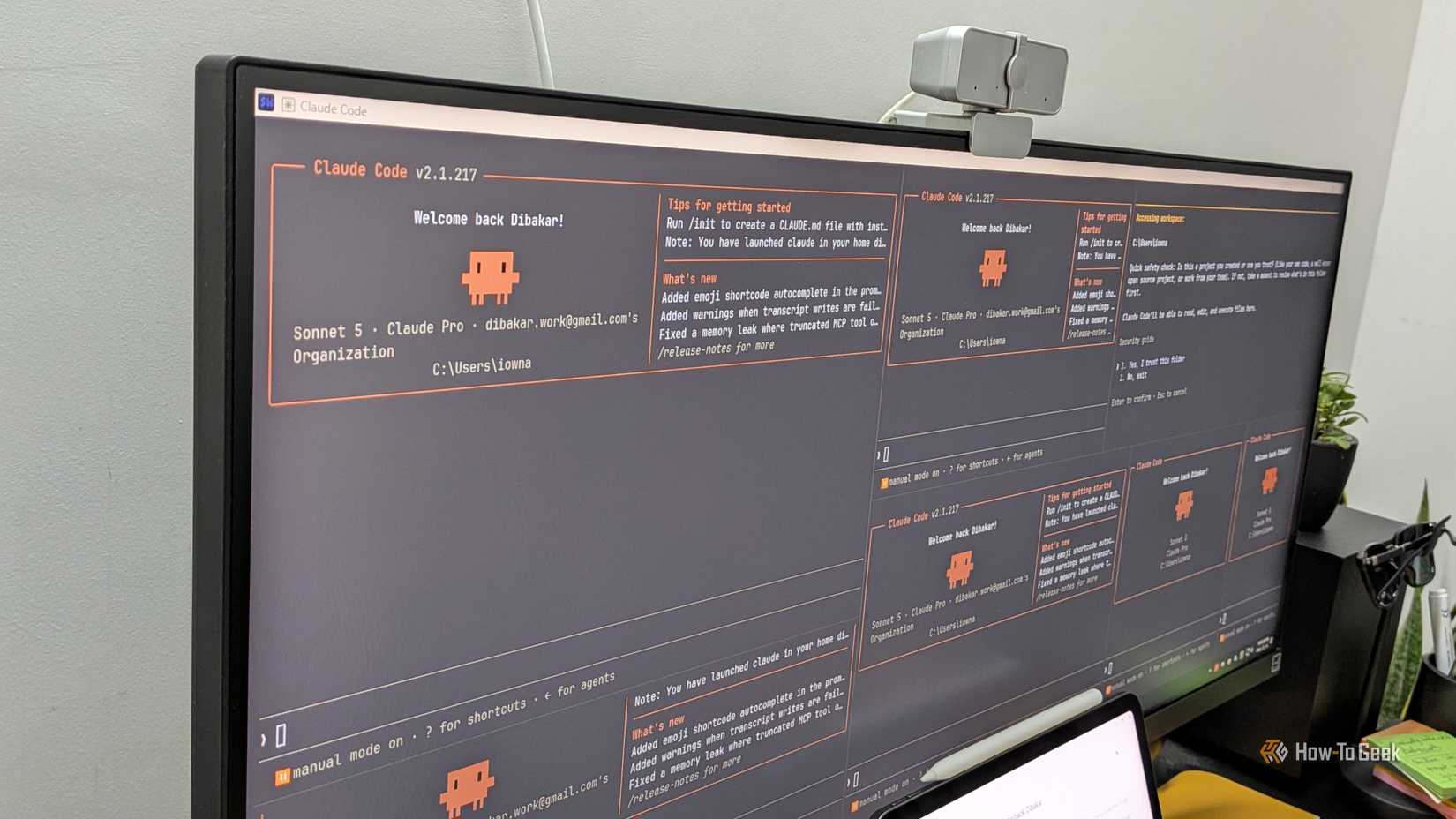 Ultrawide monitor showing four tiled Claude Code terminal windows all displaying the welcome back Dibakar startup screen.