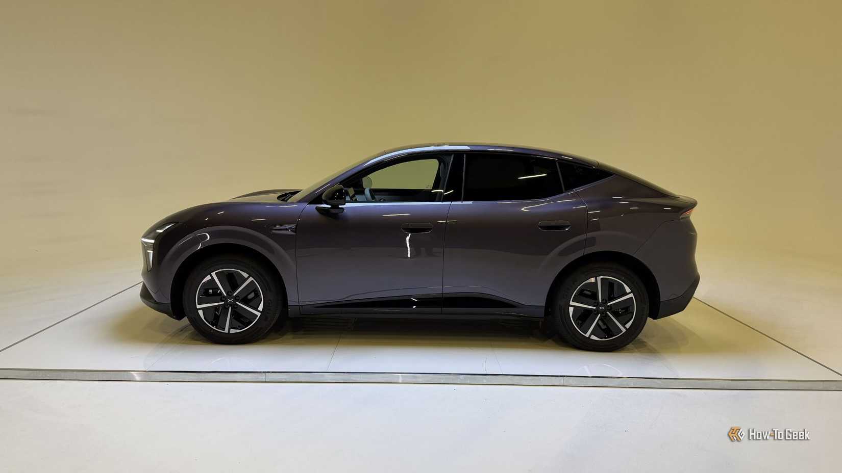 Static side profile shot of a purple XPENG L03 in a studio.