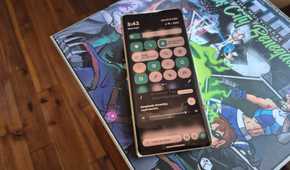 Quick status icons on a Motorola Razr Fold on top of a board game box.