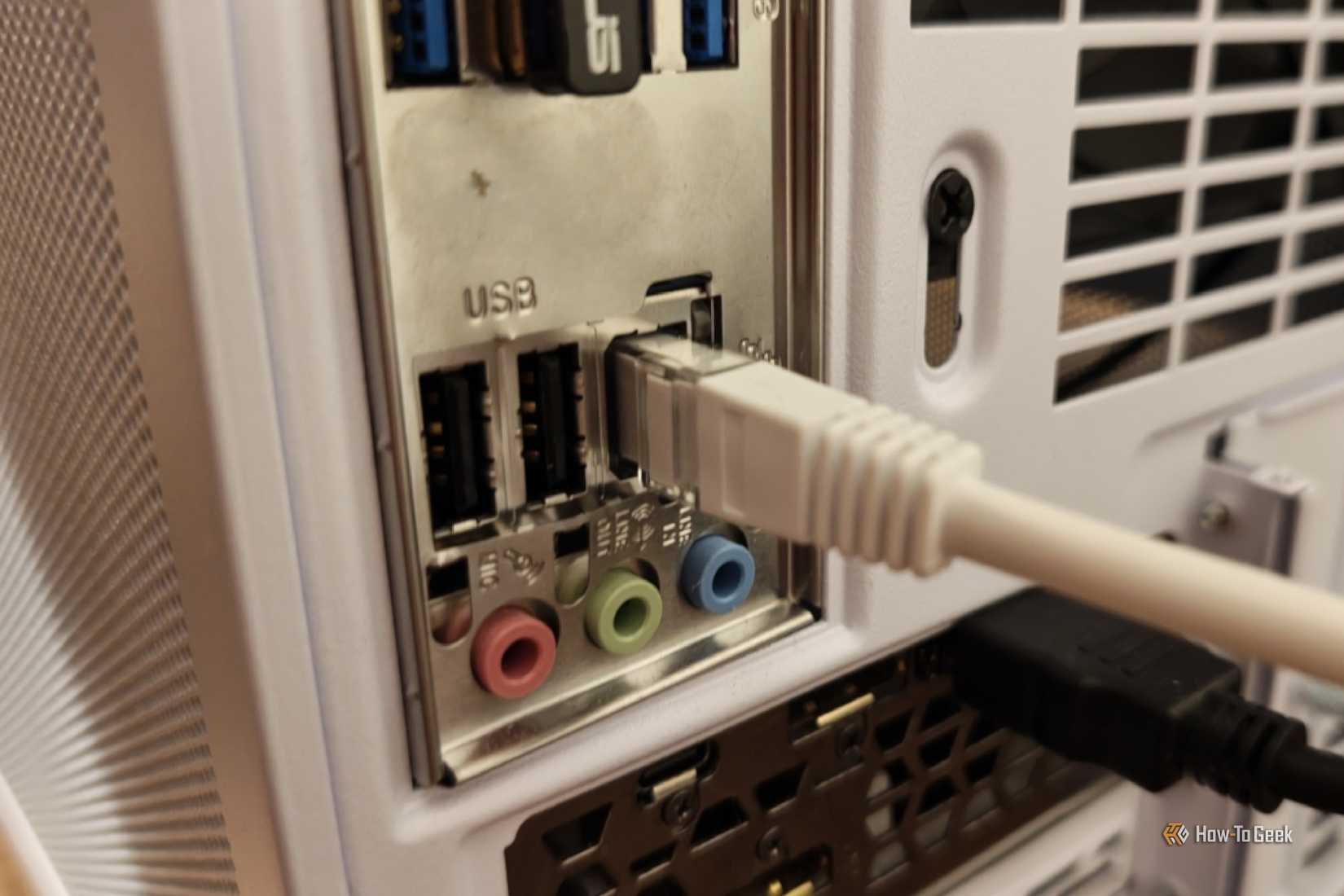 An Ethernet cable plugged into the back of a desktop PC.