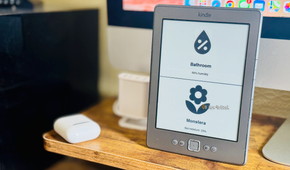 A Kindle 4 displaying a dashboard showing information about bathroom humidity and the soil moisture of a plant.