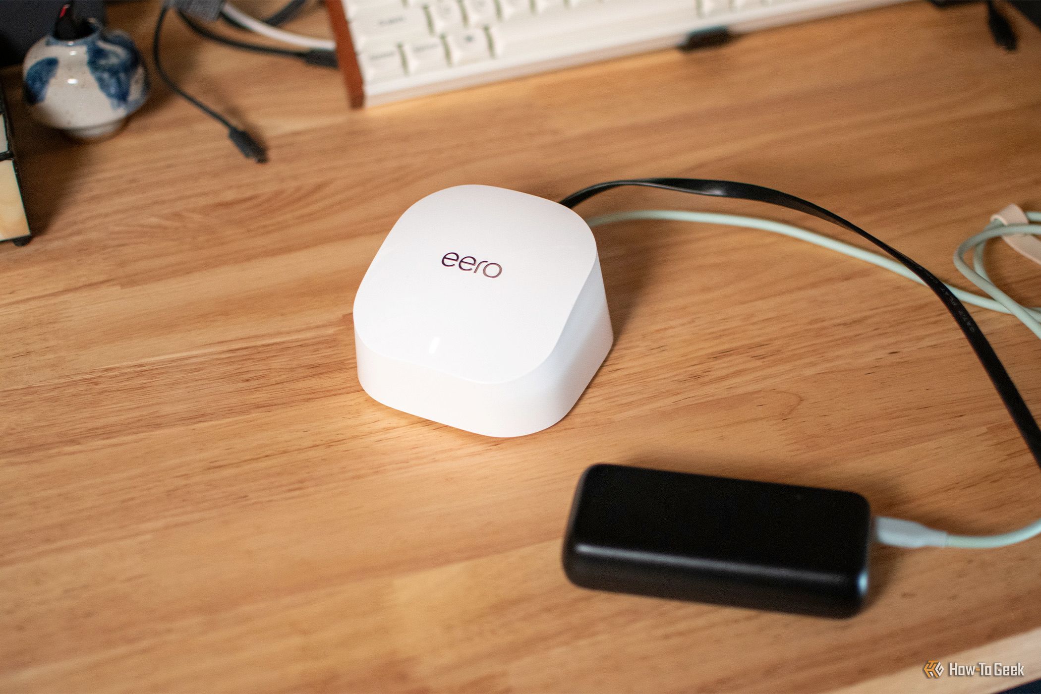 A top-down view of an Eero Wi-Fi router and power bank.