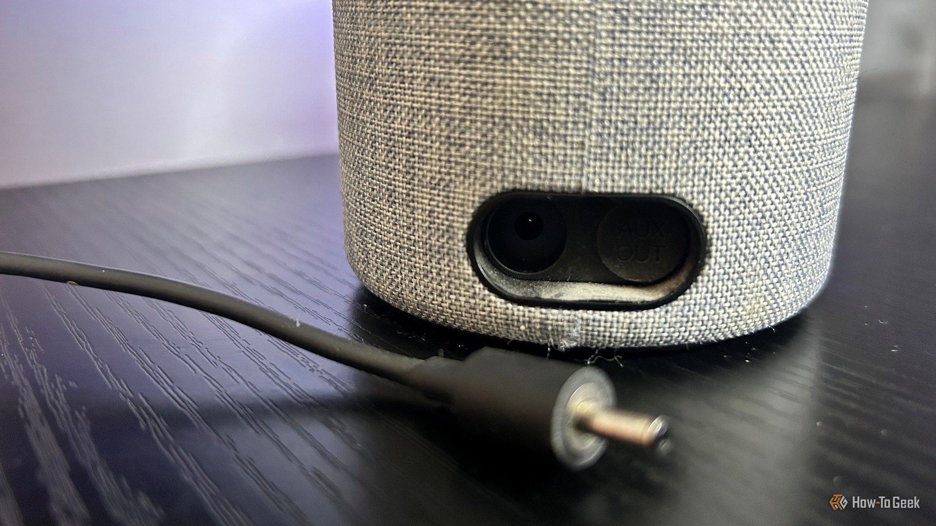 An Amazon Echo Gen 2 with its connection diconnected and placed on the desk next to it.