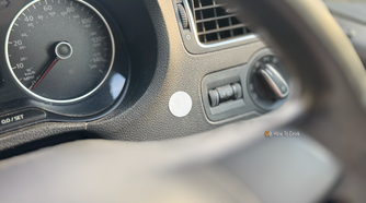 An NFC tag stuck to the dashboard of a car.