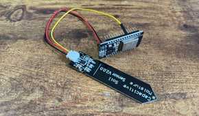 Capacitive soil moisture sensor and ESP32 development board mounted in a black pin header bracket photographed upside down.