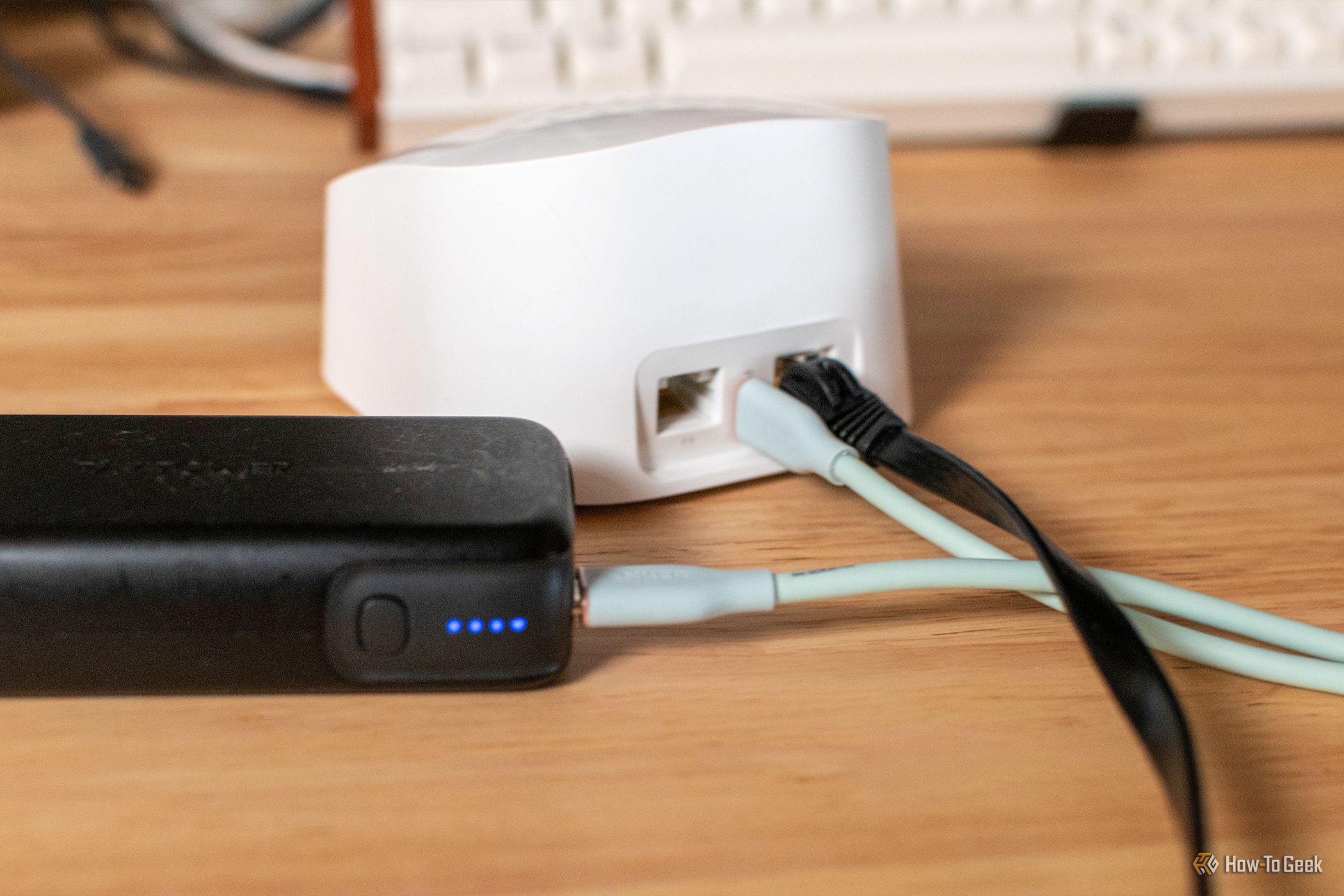 Eero router and power bank sitting on a desk.